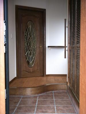 アールの上り框とステンドグラス入りの輸入ドアの玄関ホールです。